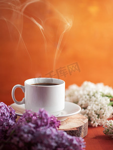 春天的早餐，早晨好，木头上放着一杯热咖啡，百合花盛开的丁香枝条