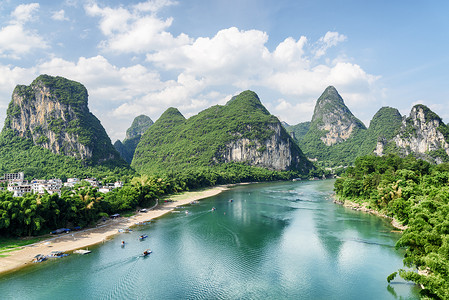 桂林摄影照片_美丽的漓江 (漓江), 与蔚蓝的水之间的奇异喀斯特山脉在桂林阳朔县。风景秀丽的绿色山丘上的蓝天背景。美丽的夏天风景