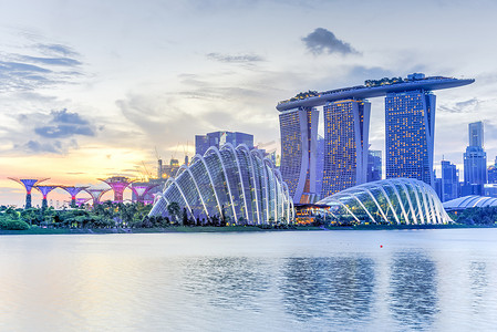 湛江海湾大桥摄影照片_黄昏时分，港湾东岸的天际线和新加坡花园灯火通明