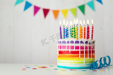 彩虹生日蛋糕配上彩色蜡烛和滴水