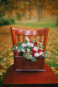 新娘捧花摄影照片_在木椅上的新娘捧花
