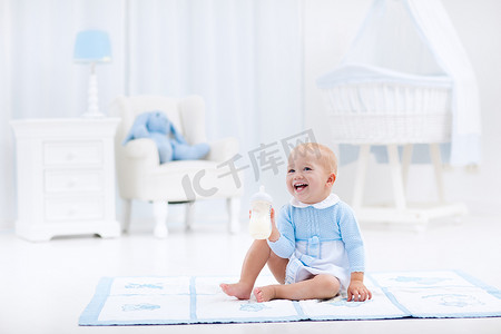 床上的男孩摄影照片_男婴与瓶喝牛奶或配方