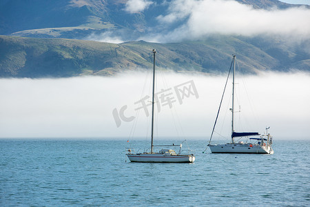 党一带一路摄影照片_在Akaroa港，蓝天，白云，雾气和海水。在新西兰坎特伯雷Akaroa港口一带的渔船和帆船也得到了支持。.