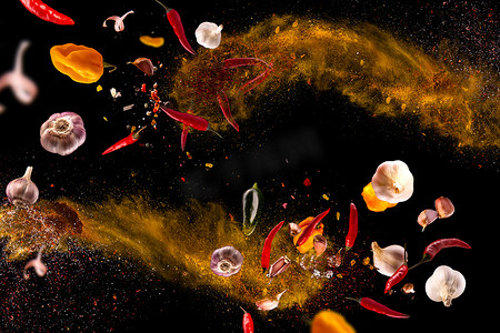 照片组合摄影照片_滚烫的红辣椒，大蒜，不同的香料粉肉桩在黑色背景上飞舞运动冻结照片组合