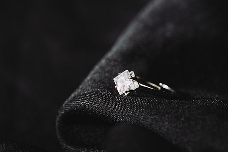 在黑色布上带有纯闪亮钻石的订婚戒指 
