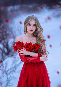 令人难以置信的金发女孩与蓝眼睛, 看着镜头。健康的长发。女伯爵夫人胸前拿着一臂鲜红的玫瑰。背景冬天风景和下落的花瓣.