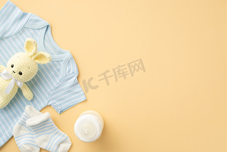 婴儿的概念。蓝色婴儿衣服、袜子、奶瓶和毛绒玩具在孤立的彩色背景图片。