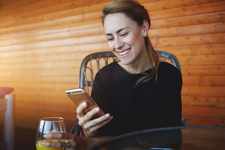 快乐的女性魅力阅读愉快的短信在手机上从她的男朋友在她休息的时间