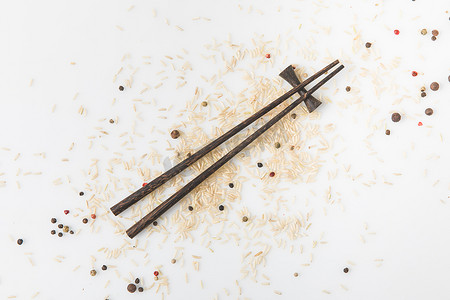 白米和香料洒在白色表面用筷子的顶部视图