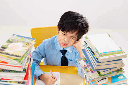 坐着的儿童摄影照片_面对作业苦恼的小学生