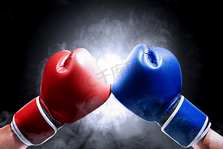 拳击黑摄影照片_两名戴着蓝色和红色拳击手套的男子的手