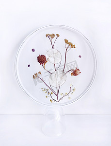 embroidery摄影照片_Handmade Embroidery with Dried Flowers and withered herbs on mesh fabric, grid, tulle, round hoop on background. Home Decor, interior, walls. Step-by-step masterclass, handicraft guide, top view