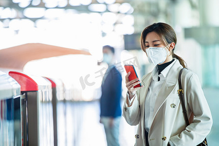 戴口罩的年轻女人站在地铁站台上