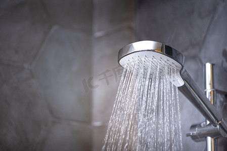 轻奢淋浴摄影照片_浴室里用自来水堵塞淋浴头.冷水疗法. 