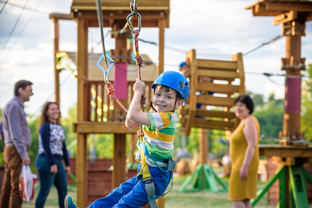 可爱的小男孩享受他的时间在一个绳索操场结构在冒险公园, 他的母亲给他帮助的手, 家庭周末活动, 春天室外