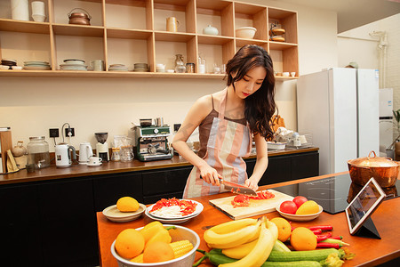 中国菜摄影照片_青年女人在家做饭