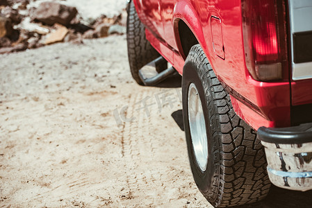 红色车轮摄影照片_沙路上的红色汽车车轮