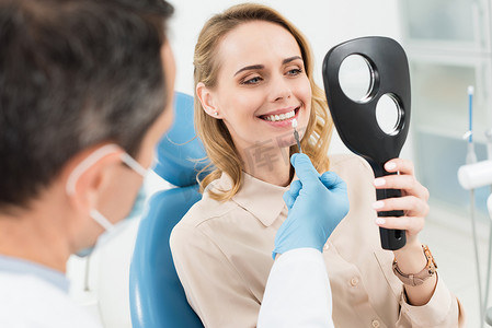选择队徽摄影照片_女性患者选择牙种植镜在现代牙科诊所的应用