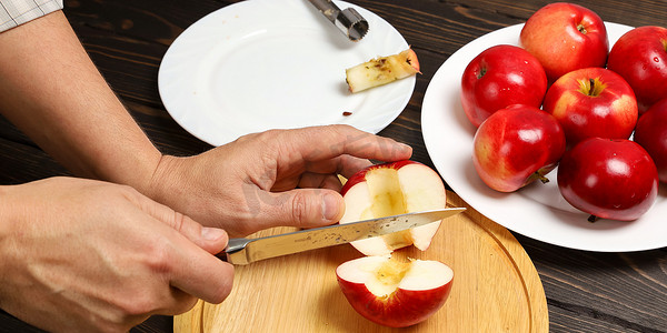 手工切碎多汁的红苹果，在切菜板上有刀，煮苹果时没有果核作为甜点，特写镜头