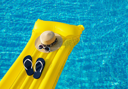 海滨暑假背景.游泳池上的充气气垫、翻盖和帽子.