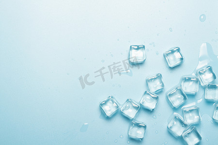 蓝色背景上有水的冰块。冰的概念为饮料。班纳平躺在地上，俯瞰四周