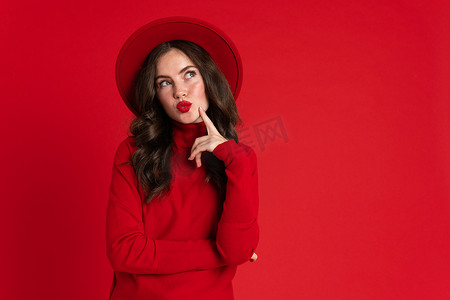 isolated摄影照片_White woman wearing hat smiling and looking at camera isolated over red background