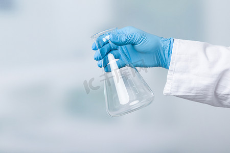 带手套的人在实验室前拿着一个空瓶子