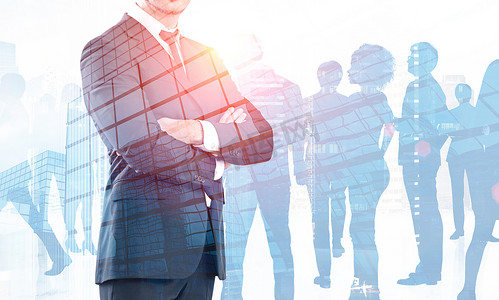 Unrecognizable confident businessman with crossed arms standing over skyscrapers background with double exposure of his colleagues. Leadership concept. Toned image