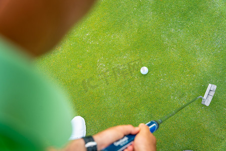打高尔夫的人，打高尔夫的细节，绿色的推杆，从上方看