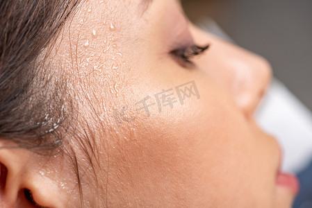 汗水摄影照片_特写年轻女子与汗水的脸遭受热在灰色 