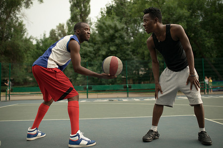 地道摄影照片_非洲裔美国人在篮球场上玩的朋友。地道的活动.