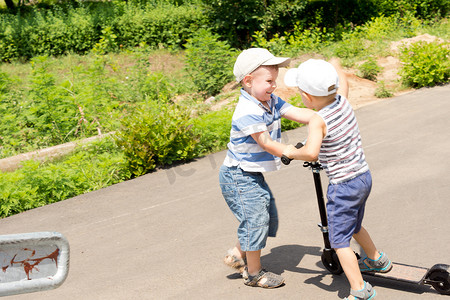 争吵摄影照片_两个年轻男孩用滑板车