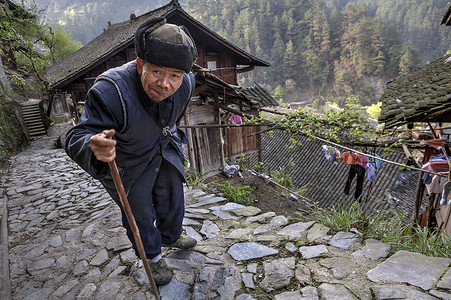 村路摄影照片_沿着石板路，铺设拄着手杖老年亚洲走.