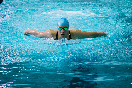 girl swimmer swims butterfly in pool