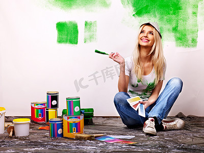 在家里的女人粉刷墙壁.
