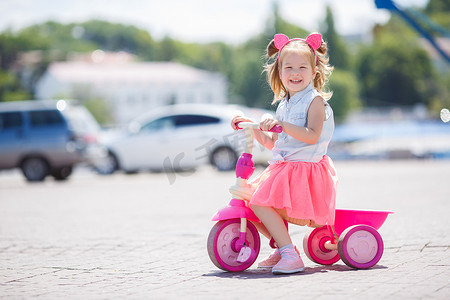 骑自行车在城市中的小女孩.