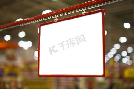 价格标签红色摄影照片_在超市的产品货架上模拟空白的红色折扣和价格标签