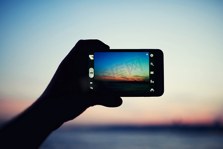 智能手机拍摄日落的手