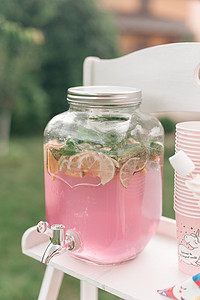 鲜榨椰子汁摄影照片_鲜榨粉红柠檬水在玻璃瓶桌上 outoors