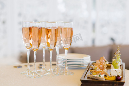 自助餐桌上放着粉红色的香槟酒和零食