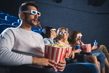 多民族朋友的选择性焦点在3d 眼镜与爆米花一起看电影在电影院