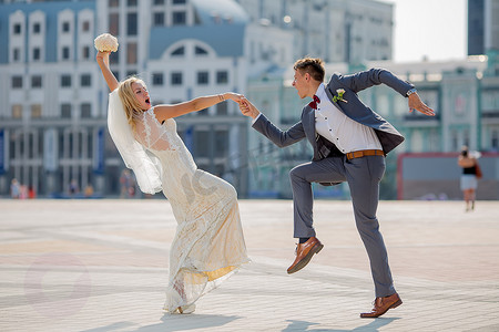 新娘和新郎在婚礼服装在镇广场上跳着火热的舞蹈