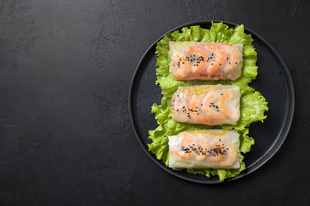 越南春卷与蔬菜,对虾在米纸上的黑色.亚洲菜.