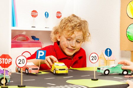  男孩玩玩具纸车
