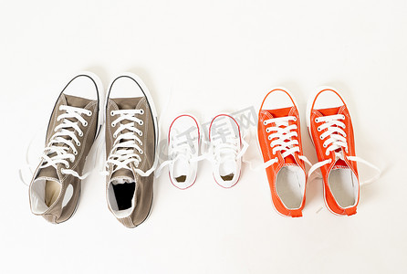 在家庭育儿教育和生活方式概念中, 父女母女在不同尺寸的白色背景复制空间上隔离的胶鞋运动鞋的概念形象.