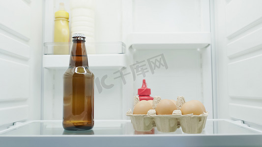 冰箱里摄影照片_冰箱里的啤酒、牛奶、鸡蛋和酱汁