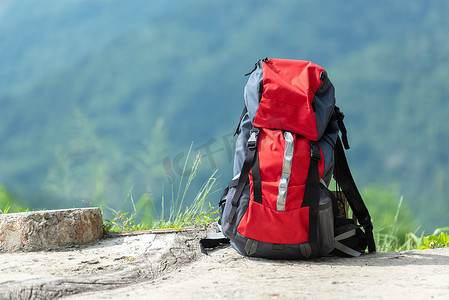 露营装备摄影照片_远足背包旅行装备在山上。项目包括旅行目的地远足和度假休闲。登山露营旅行户外旅行器材的平铺.