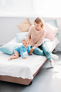 一起看看表情包摄影照片_高角度看母亲和孩子在床上一起度过的时间在家庭