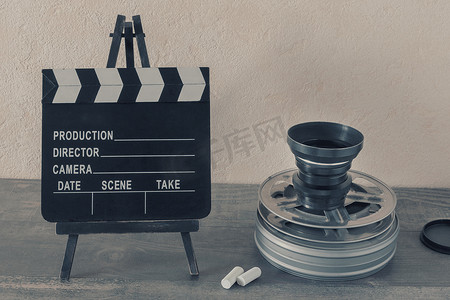a4夹板摄影照片_工作室里有一个装有电影的金属盒子、一个电影摄影机的镜头和一个装有粉笔的夹板