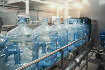 装瓶纯净水的水厂生产线或输送带上的塑料PET瓶或加仑